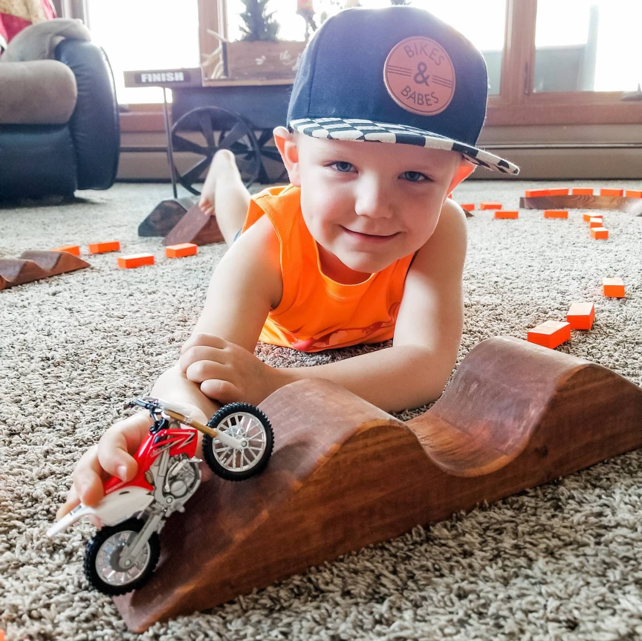 happy toddler with dirtbik and wooden track