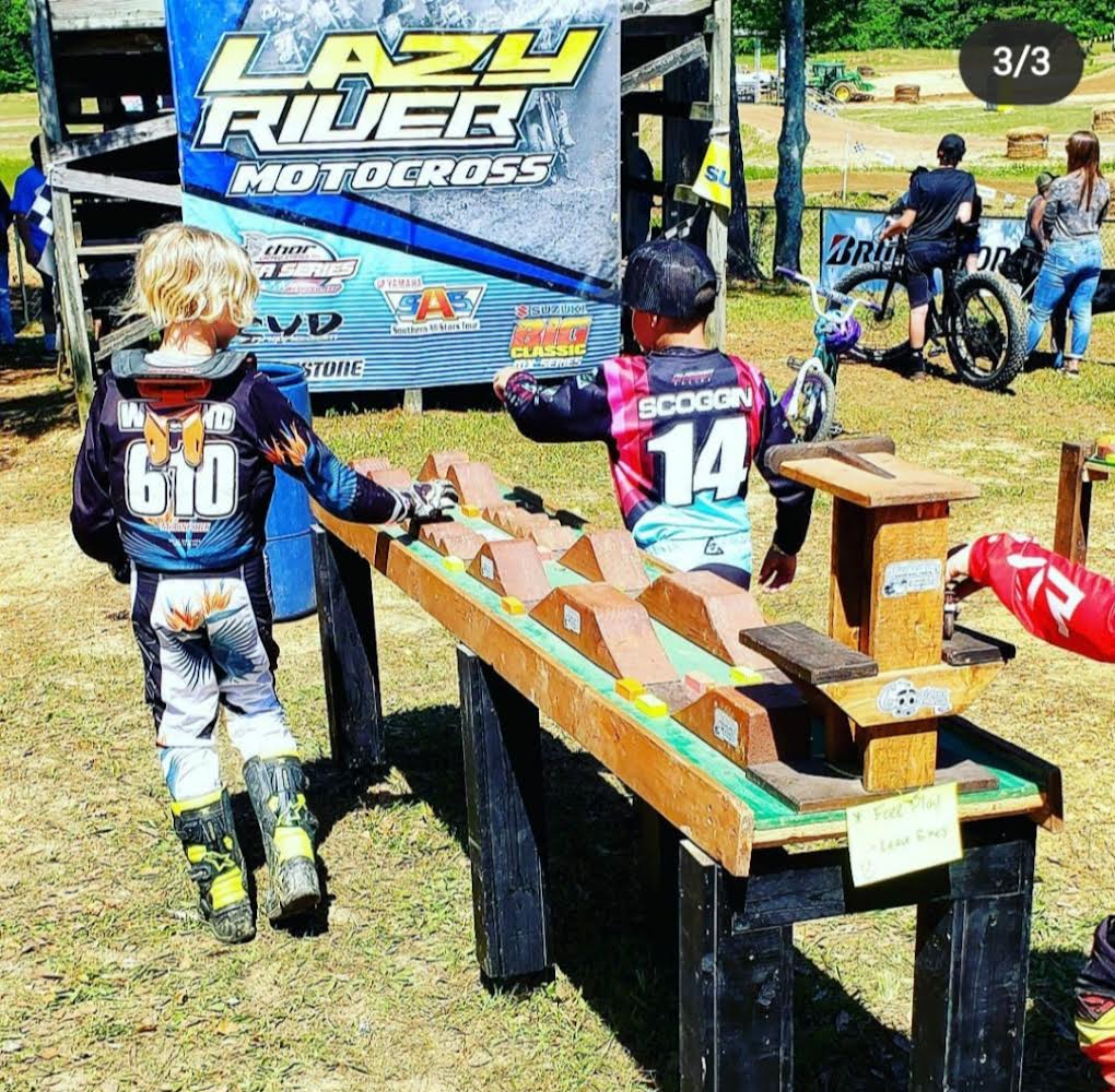 boy playing with dirt bike, 2 elementary boys playing at dirt bike track, monster truck, wooden track