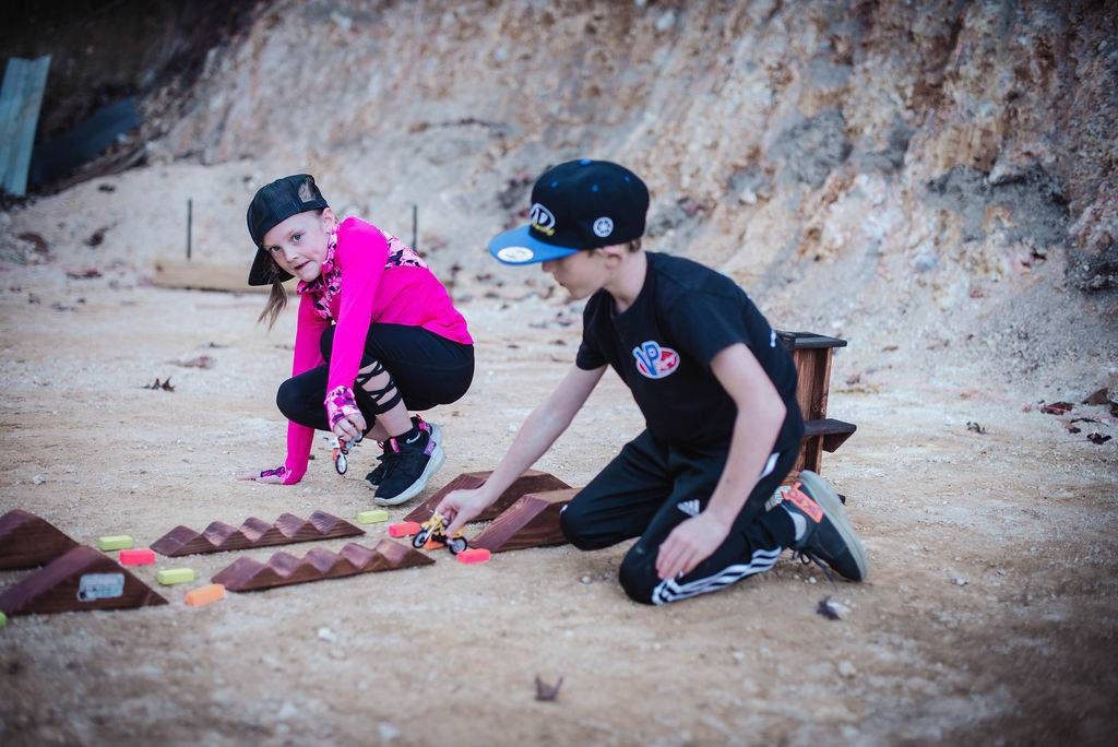 Brother and sister playing with toy dirt bikes g at dirt bike track, monster truck, wooden track, neon blocks