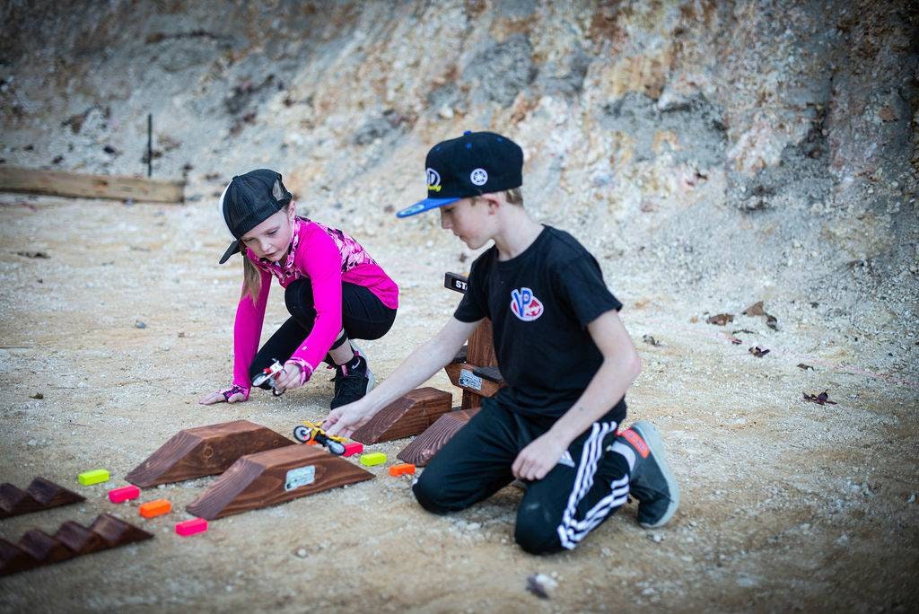 Brother and sister playing with toy dirt bikes g at dirt bike track, monster truck, wooden track, neon blocks