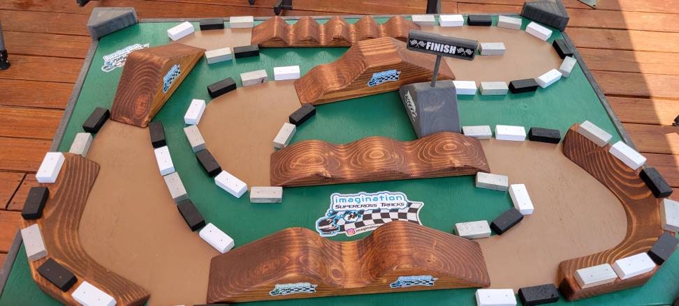 imagination supercross, woodshop, dirt bike rider, wood shop, dirtbike helmet, neon blocks on track table