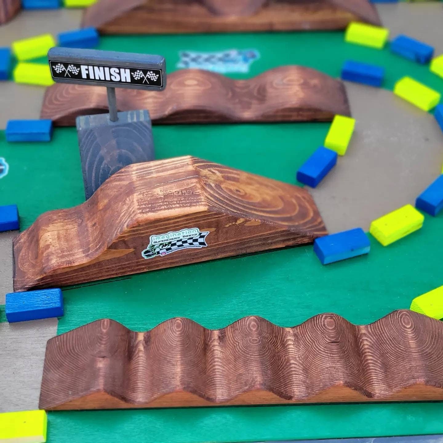 imagination supercross, woodshop, dirt bike rider, wood shop, dirtbike helmet, neon blocks on track table