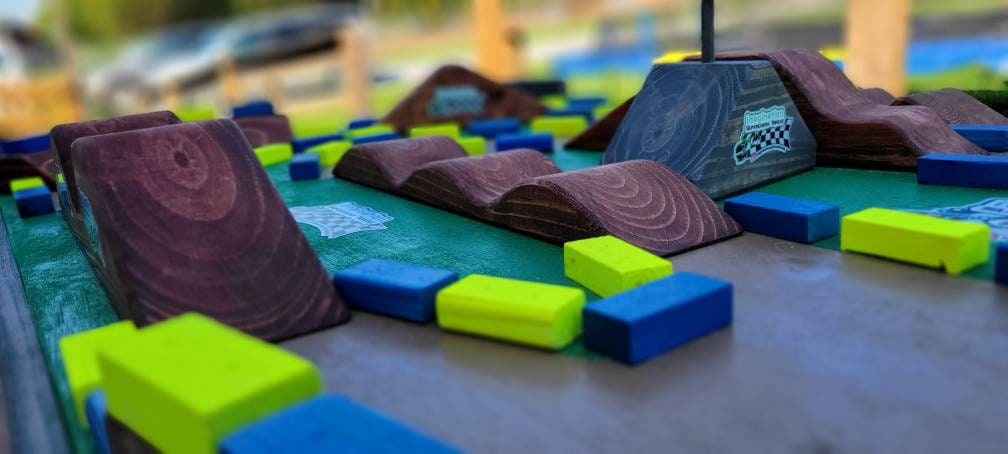 imagination supercross, woodshop, dirt bike rider, wood shop, dirtbike helmet, neon blocks on track table, double section