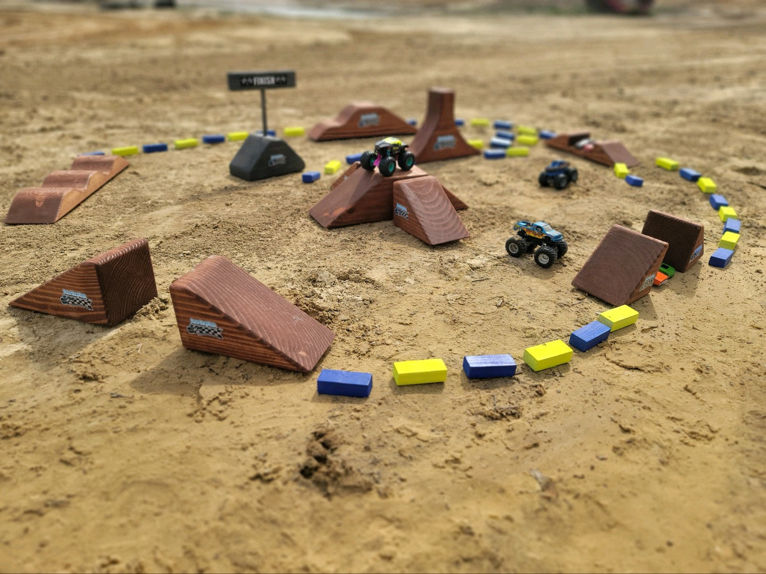 toy wooden track with big monster track and monster trucks jumping