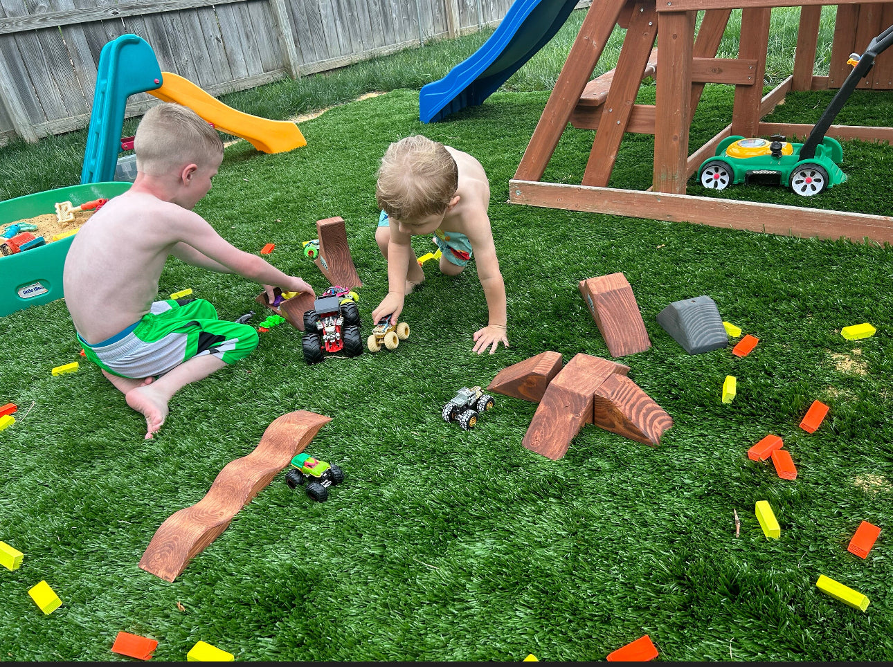 boy and girl playing with dirtbikes in the dirt, wearing dirtblike apparel and hats