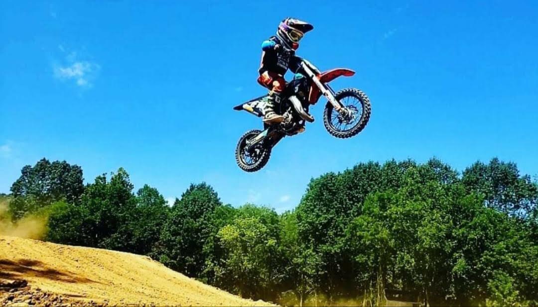 boy riding yamaha dirtbike, jumping on sunny day