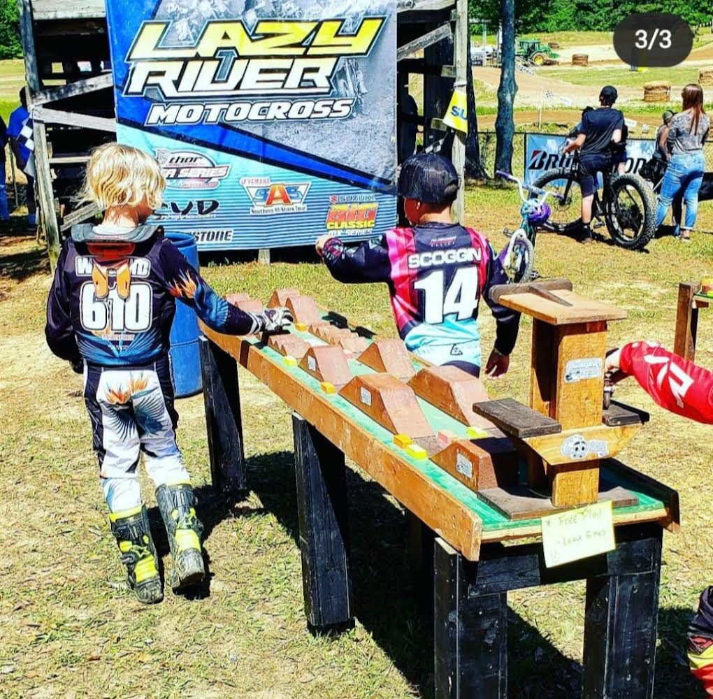  boy playing with dirt bike, 2 elementary boys playing at dirt bike track, monster truck, wooden track