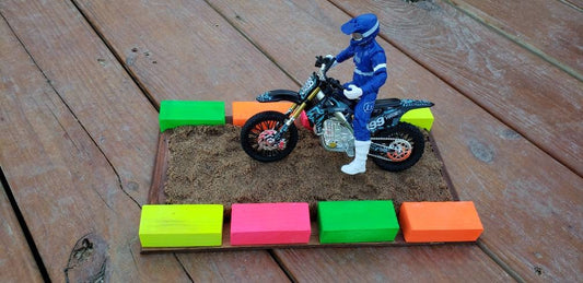 sand section with neon blocks with blue dirt bike rider and dirt bike