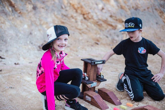 Brother and sister playing with toy dirt bikes g at dirt bike track, monster truck, wooden track, neon blocks